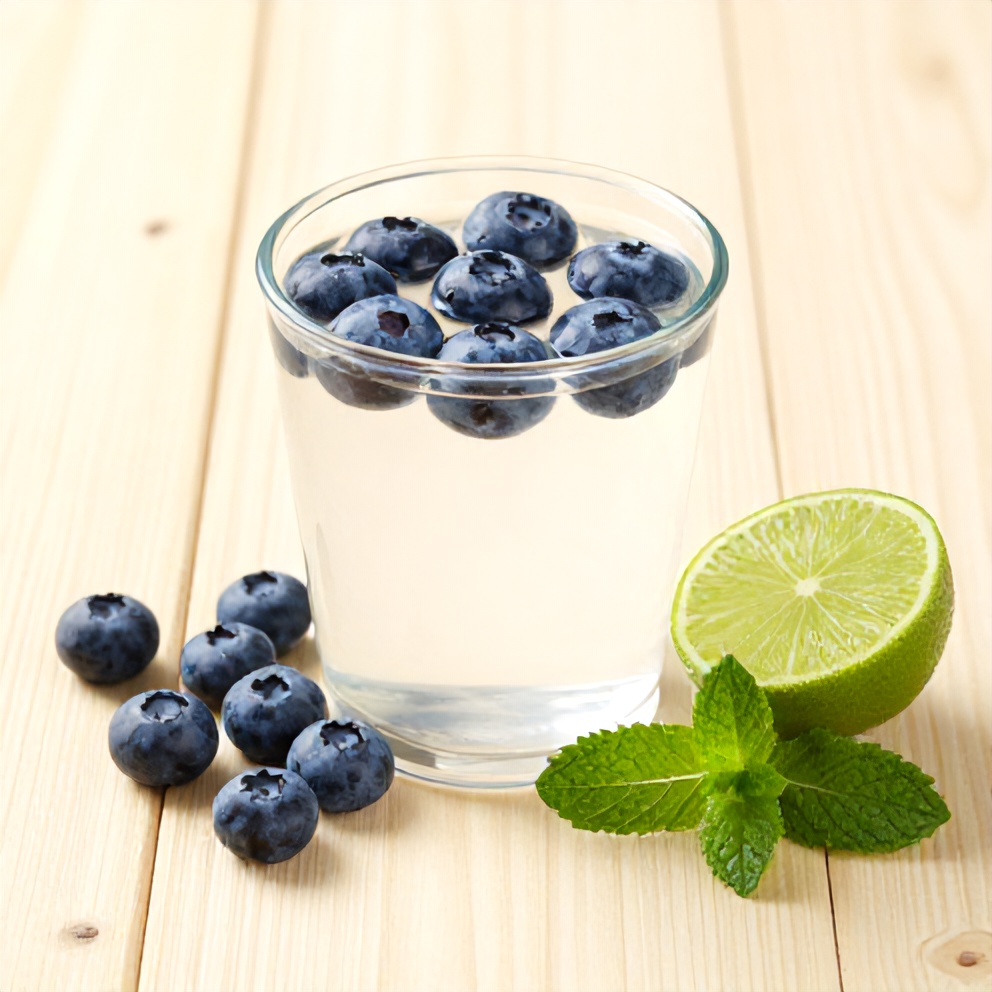 Blueberries, coconut water, lime, and mint leaves on a wooden surface
