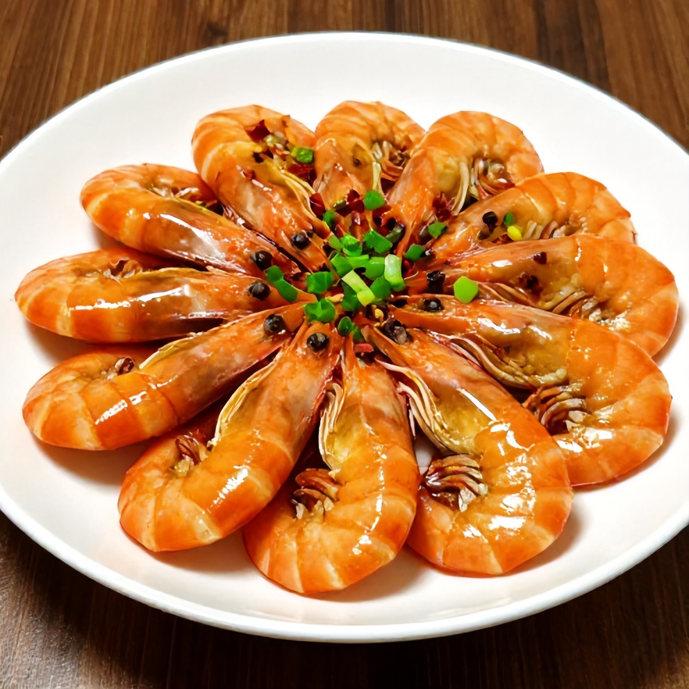 Plated honey garlic shrimp with green onions and red pepper flakes on a white plate