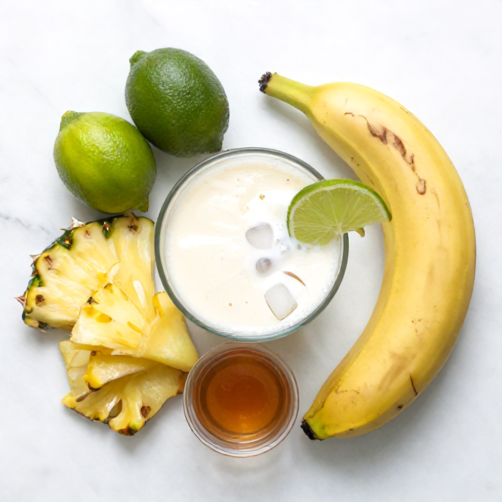 Ingredients for Coconut Key Lime Smoothie: coconut milk, limes, frozen pineapple, banana, ice cubes, and honey
